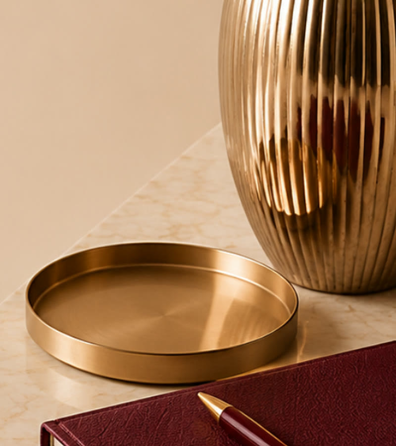 A gold vase and tray on marble